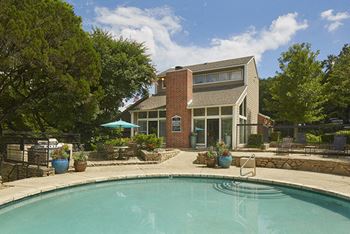 A pool with a house in the background